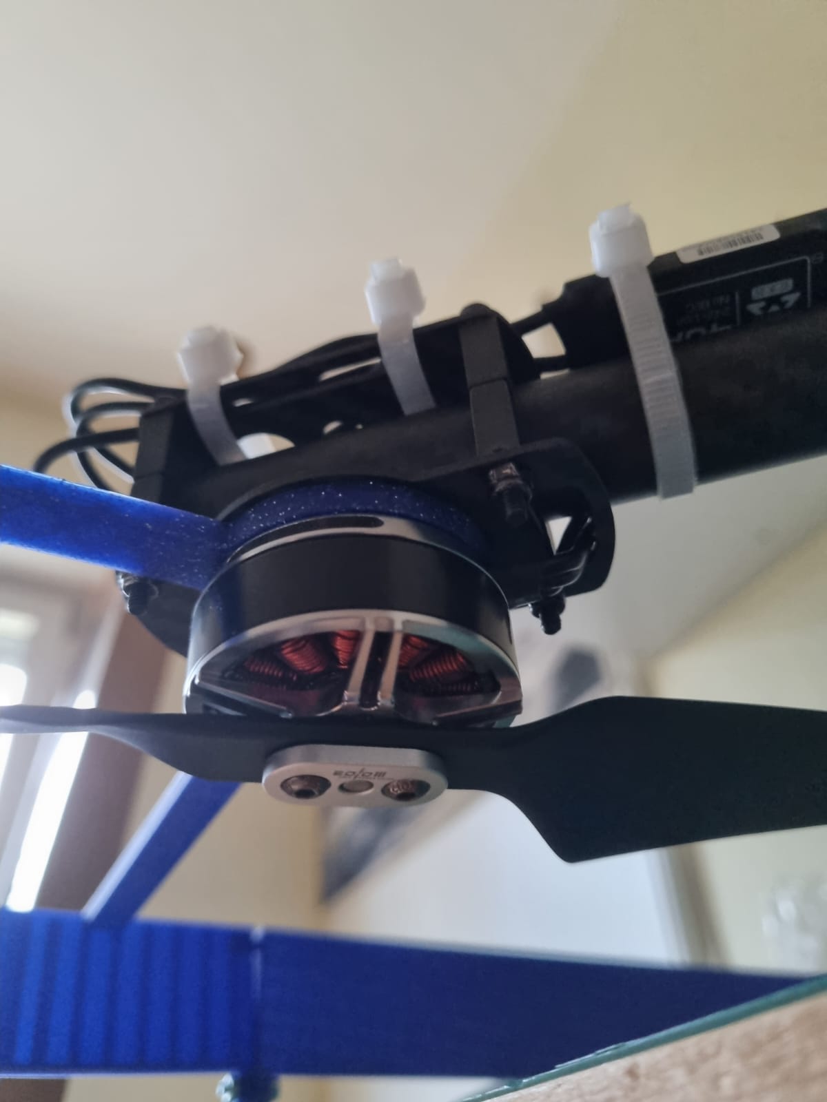 Brushless motor with downward-facing propeller on carbon arm