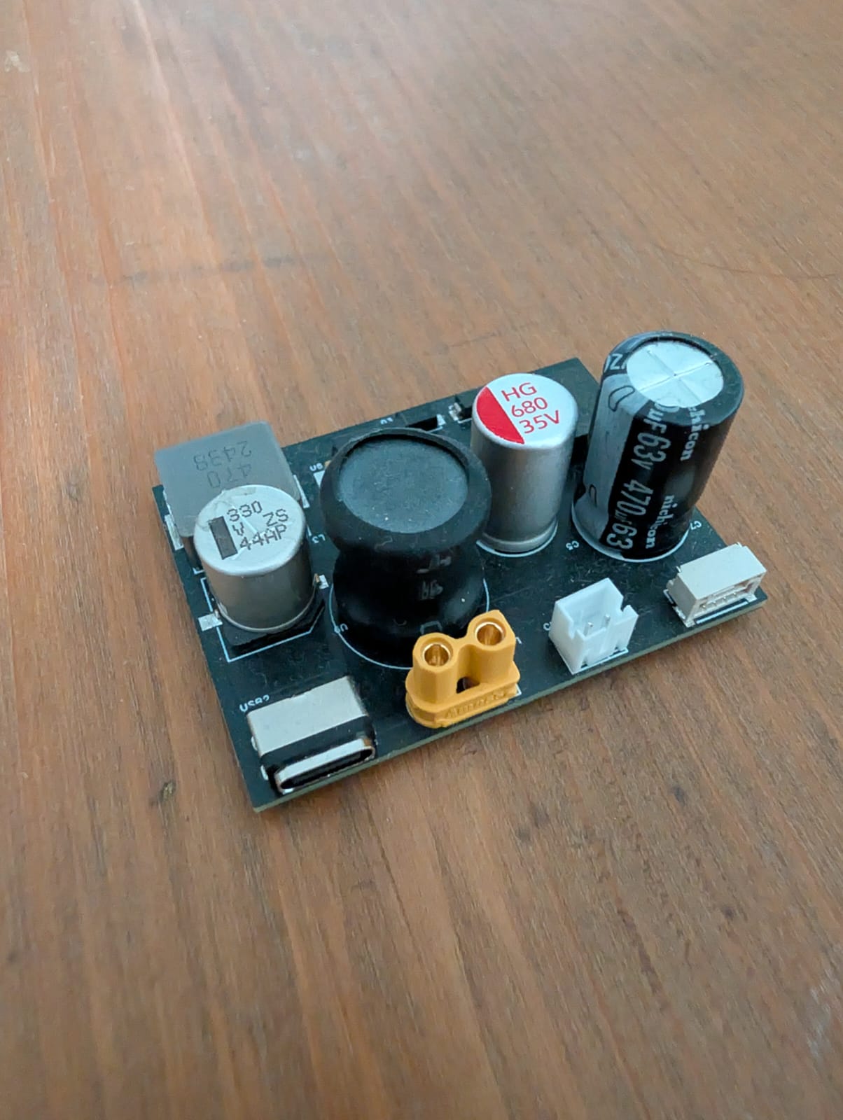 Assembled custom power distribution PCB with capacitors, inductor, USB-C, and XT30 connector